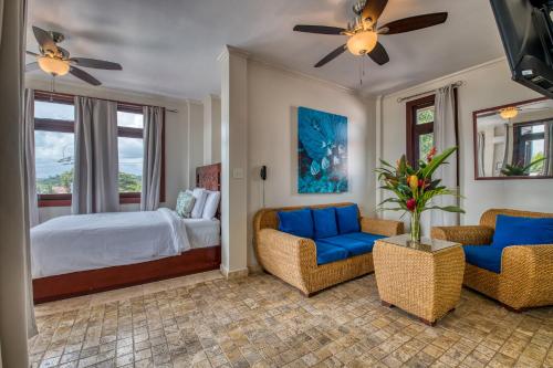 a living room with a bed and two chairs at Hotel Palma Royale in Bocas Town