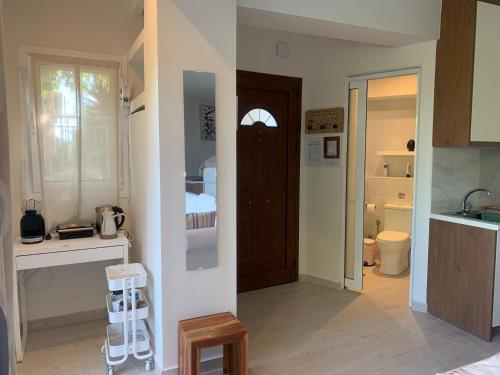 a kitchen with a sink and a door to a room at Amfiteatriko Studio Sea View Oropos Attiki in Kalamos