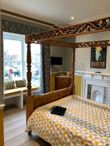 a bedroom with a canopy bed with a laptop on it at Dairy Guest House in York