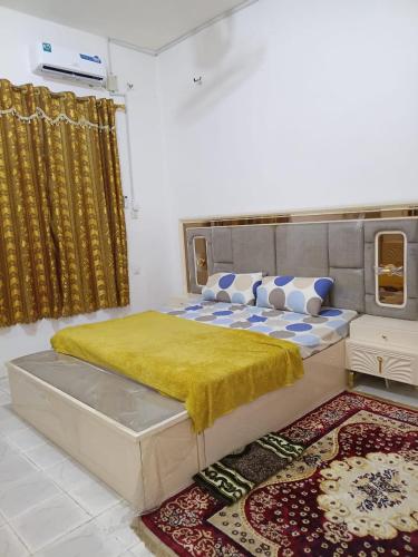 a bedroom with a large bed with a yellow blanket at Al-Ahmari Holiday Apartment in Mogadishu