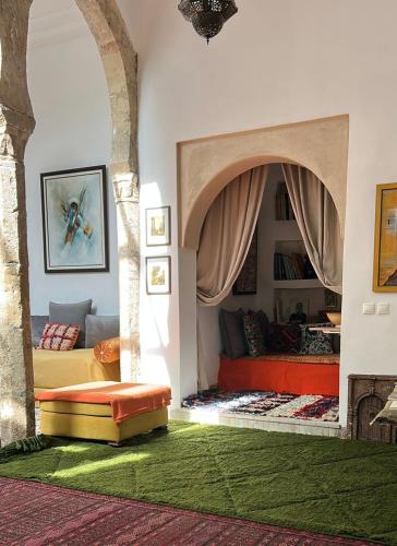 a living room with two beds in a room with a green rug at Dar DIESUS NOOR in Azemmour