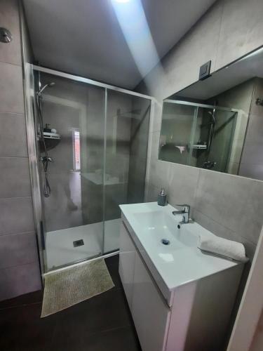 a bathroom with a white sink and a shower at Vista Real in Mugardos
