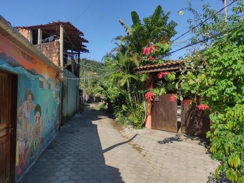 an alley with a mural on the side of a building at Aldeia Itamambuca Chalé Camping Ubatuba in Ubatuba