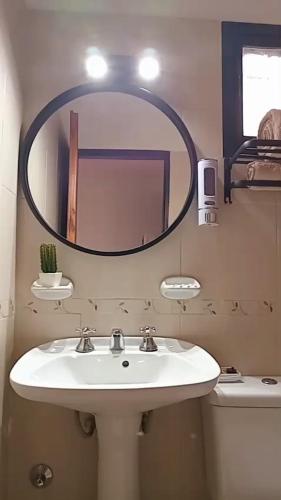 a bathroom with a sink and a large mirror at Alojamiento Las Camelias in Concordia