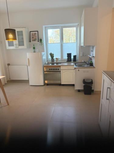a kitchen with a white refrigerator and a stove at Landglück in Ibbenbüren