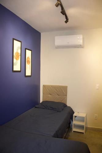 a bedroom with a bed and a blue wall at APT térreo completo - 2 Quartos - 2 Ar-condicionados, Cozinha, Garagem, WI-FI- Maurício Nassau, Perto de tudo in Caruaru