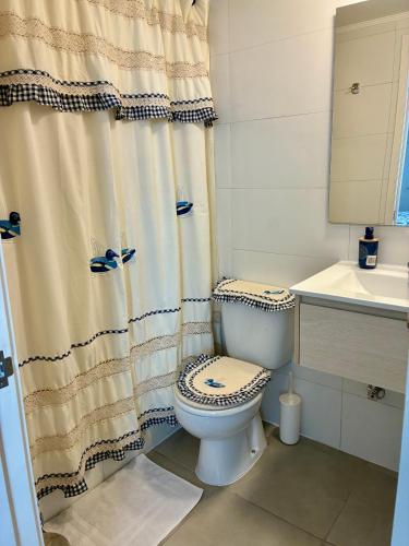 a bathroom with a toilet and a shower curtain at Marina del Sol Executive Apartment in Talcahuano