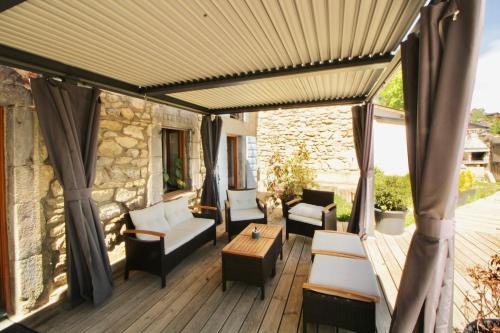 a patio with white furniture on a wooden deck at Lodge Les Cariolettes in Font-Romeu-Odeillo-Via