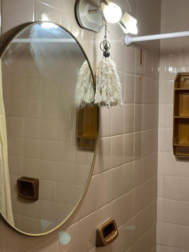 a bathroom with a round mirror on a wall at Departamento zona sur 1 dormitorio in Santa Fe