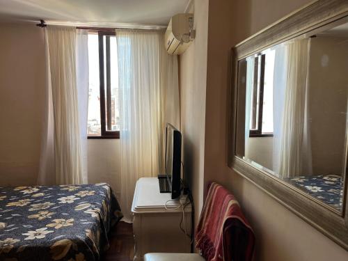 a bedroom with a bed and a mirror and a television at Departamento zona sur 1 dormitorio in Santa Fe
