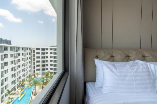 a bed in a hotel room with a window at New Capri Condo in Bang Tao by Lofty in Ban Thalat Choeng Thale