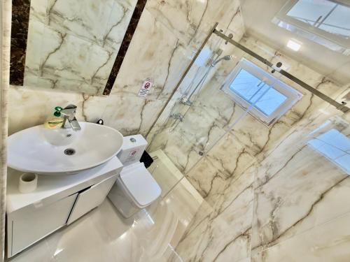 a white bathroom with a sink and a shower at Home Ler in Yeghipatrush