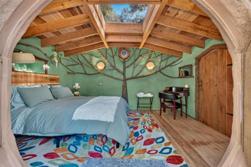 a bedroom with a tree mural on the wall at Hobbit Hideout in Watsonville