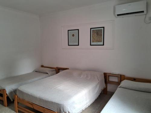 a room with two beds and two pictures on the wall at Sarmiento 595 in Paso de los Libres
