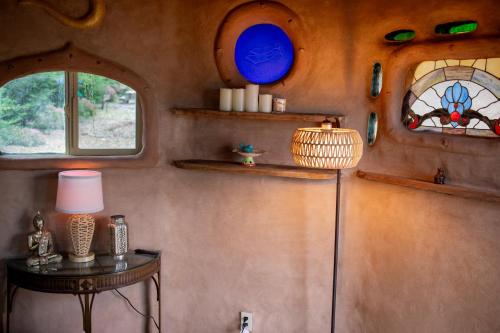 a room with two windows and a table with a lamp at Hobbit Hideout in Watsonville