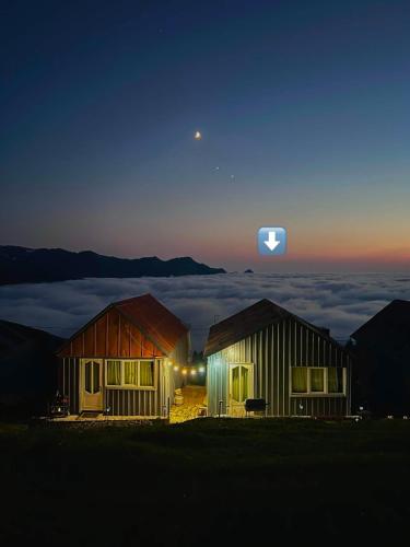 two houses on top of a mountain at night at Gomismta Golden Hour Cottages in Gomi