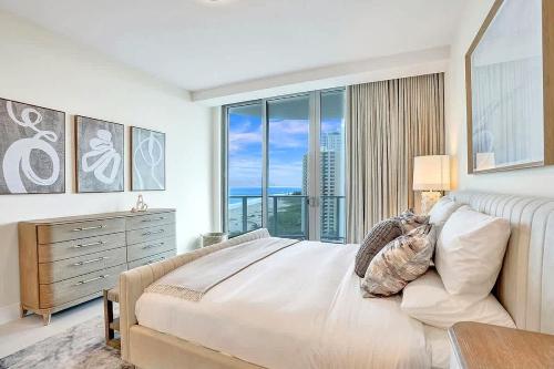 a bedroom with a large bed and a large window at Luxury Ocean View 2BR in Riviera Beach