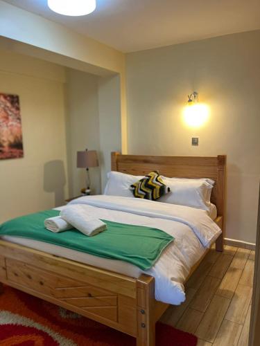 a bedroom with a large wooden bed with white pillows at Floma Homes in Nairobi