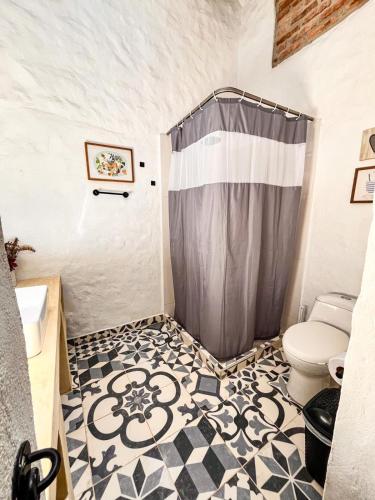 a bathroom with a shower curtain and a toilet at Casa Luna Hotel Campestre & Spa in San Gil