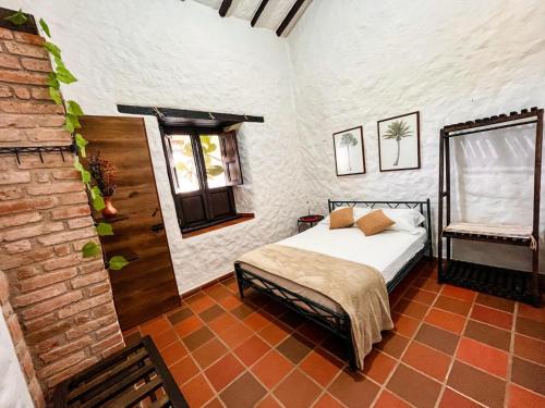 a bedroom with a bed and a brick wall at Casa Luna Hotel Campestre & Spa in San Gil