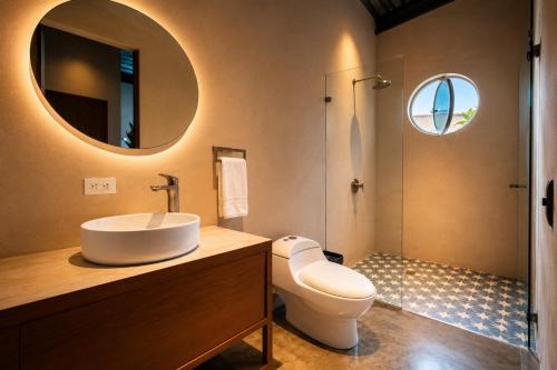 a bathroom with a sink and a toilet and a mirror at Capybara Hostel - Boutique hostel in Villavicencio