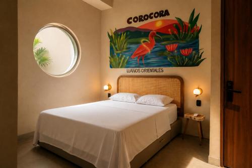 a bedroom with a bed with a painting on the wall at Capybara Hostel - Boutique hostel in Villavicencio