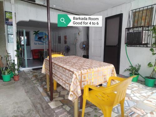 a table and two yellow chairs in a patio at SJ Transient House in San Fernando
