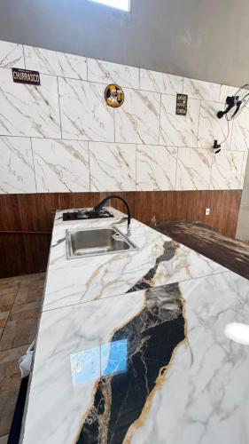 a kitchen with a marble counter top with a sink at Top festas in Campinas