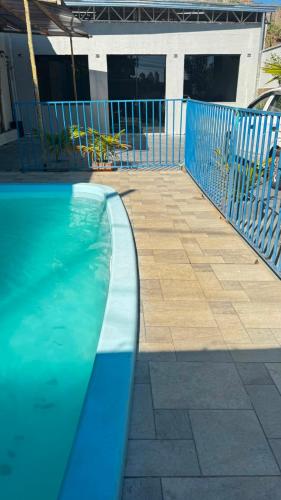 a swimming pool next to a blue fence at Top festas in Campinas