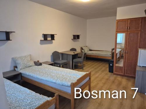 a room with two beds and a dining room with a table at Bursztyn in Władysławowo