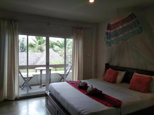 a bedroom with a bed with a view of a patio at THAMONWAN hostel in Cha Am