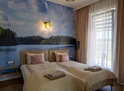 two beds in a bedroom with a painting on the wall at Domek dwóch jezior z jakuzzi, Chojno pojezierze Brodnickie in Chojno
