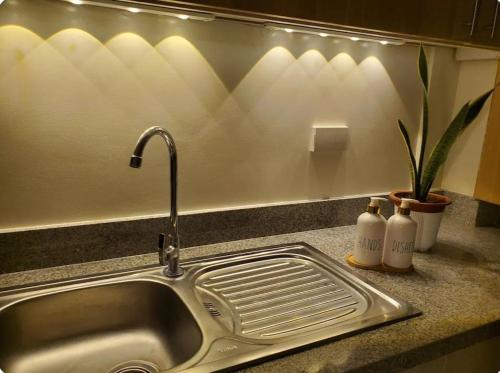 a kitchen sink with a faucet and two bottles of soap at The Coastal Luxe Suite in Samal