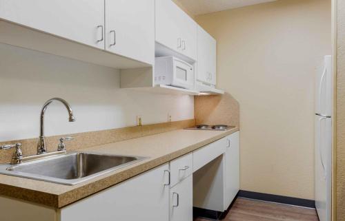 a kitchen with white cabinets and a sink at Extended Stay America Suites - Evansville - East in Evansville