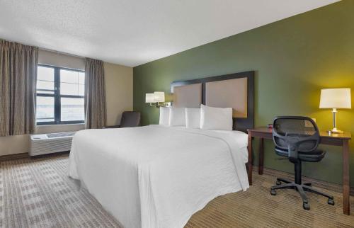 a hotel room with a large bed and a chair at Extended Stay America Suites - Frederick - Westview Dr in Frederick