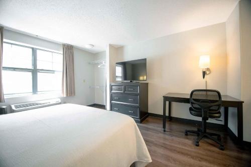 a hotel room with a bed and a desk and a television at Extended Stay America Suites - Boston - Woburn in Woburn