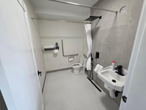 a small bathroom with a toilet and a sink at Lakeview Main Floor Suite 104 in Peachland