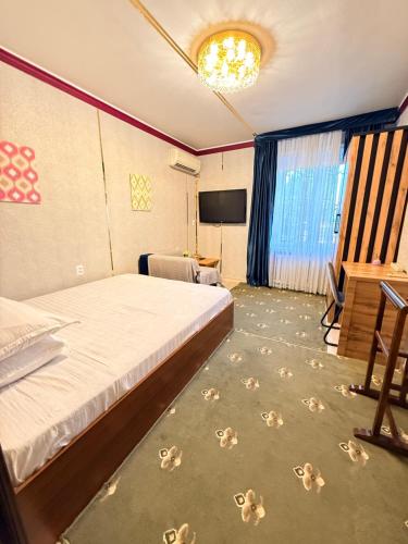 a hotel room with a bed and a television at Heyvah - Guest House in Tashkent in Tashkent