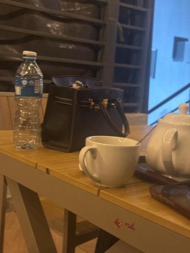 a purse and a cup on a table with a bag at Tahir in Kano