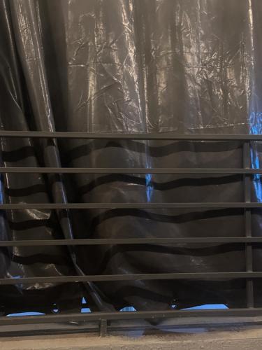 a metal rack with a black plastic sheet at Tahir in Kano