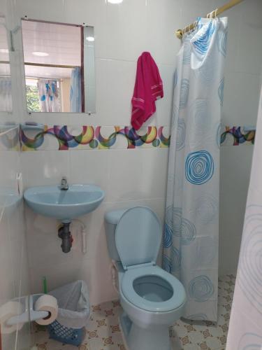 a bathroom with a blue toilet and a sink at Hotel GinaMar Ladrilleros in Buenaventura