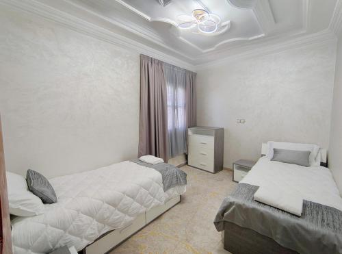 a bedroom with two beds and a television in it at Villa Drayd in Ait Melloul