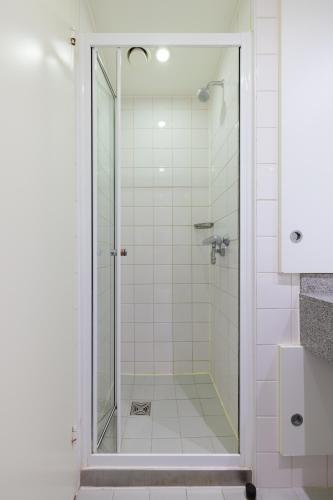 a shower with a glass door in a bathroom at Princes Gardens in London