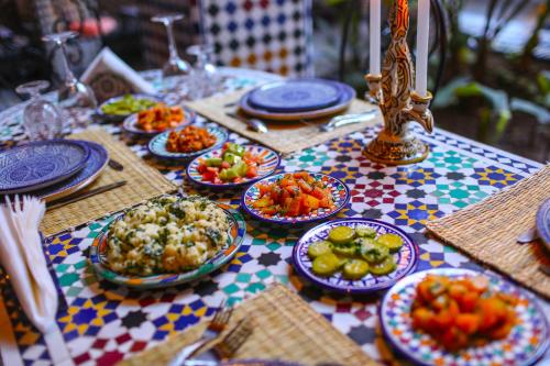 una tavola ricoperta di piatti di cibo su un tavolo di Riad Toyour- Riad of birds a Fes