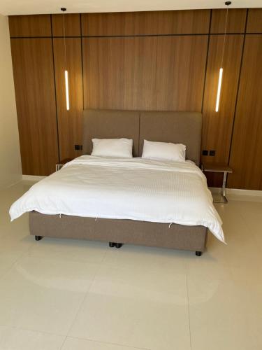 a bedroom with a large bed with wooden cabinets at شاليهات دبليو العمارية in Al ‘Ammārīyah