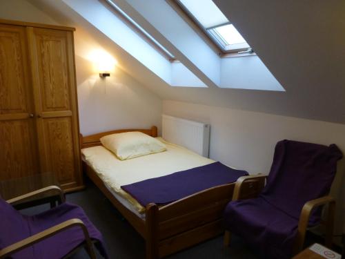 a small bedroom with a bed and two chairs at Willa Focus in Mielno