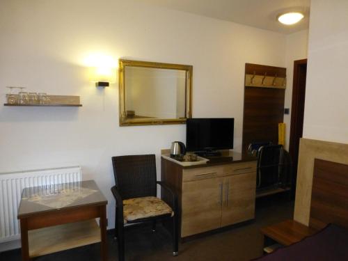 a room with a desk with a tv and a mirror at Willa Focus in Mielno