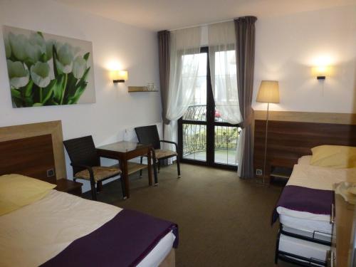 a hotel room with two beds and a table and chairs at Willa Focus in Mielno