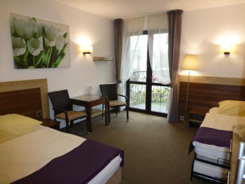 a hotel room with two beds and a table and chairs at Willa Focus in Mielno