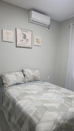 a bedroom with a bed and a air conditioner on the wall at Lar doce lar in Paragominas